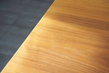 Kaba ahşap bir masada ışık huzmeleri ve arka planda fayanslar