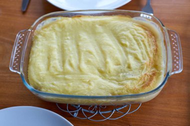 Hachis Parmentier, ahşap bir masadaki saydam tabakta fırından çıktı.