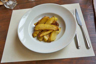 Tahta bir tabakta servis edilen kızarmış patatesler..