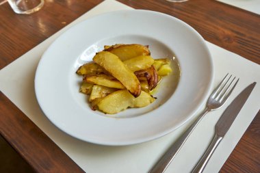 Tahta bir tabakta servis edilen kızarmış patatesler..