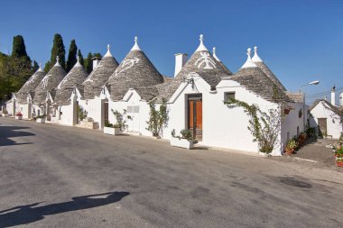 Alberobello / Apulia / İtalya / Ekim 2019: Alberobello kentindeki geleneksel Trulli evleri üzerinde güneş parlıyor, Apulia, İtalya