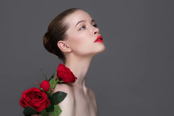 Όμορφο κορίτσι με το λουλούδι κόκκινα τριαντάφυλλα — Φωτογραφία Αρχείου