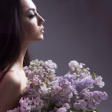 Çiçekler ıslak pencerenin arkasında kızla