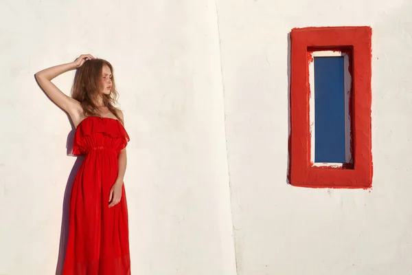 Όμορφο κορίτσι στο κόκκινο φόρεμα κοντά στο σπίτι — Φωτογραφία Αρχείου