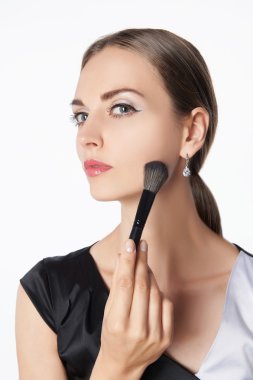 Makyaj yapan genç bir kadın.