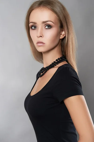 Vrouw in zwarte jurk en halsketting — Stockfoto