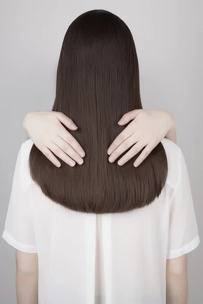 Vrouwen handen op mooie gezonde lange haren — Stockfoto