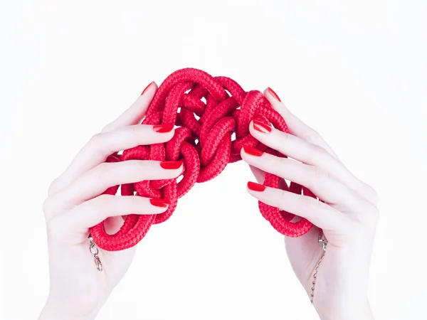 Manikür kırmızı ipi tutan elleriyle — Stok fotoğraf