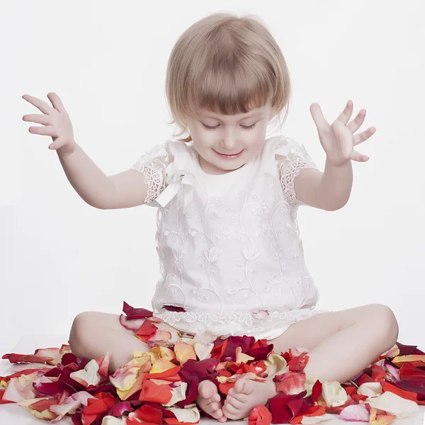 Beautiful little girl with flower petals — Stock Photo, Image