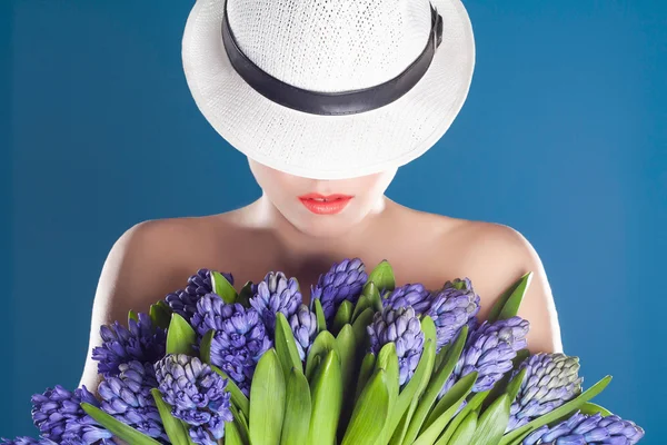 Schöne Frau mit Hut und Blumen — Stockfoto