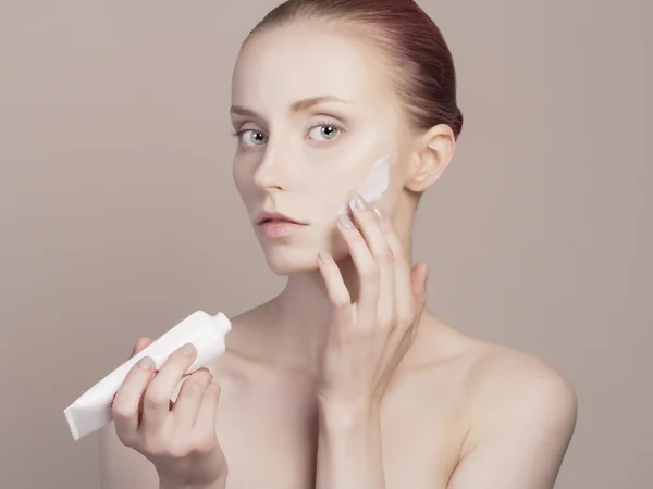 Jonge vrouw zorgt voor gezichtshuid — Stockfoto