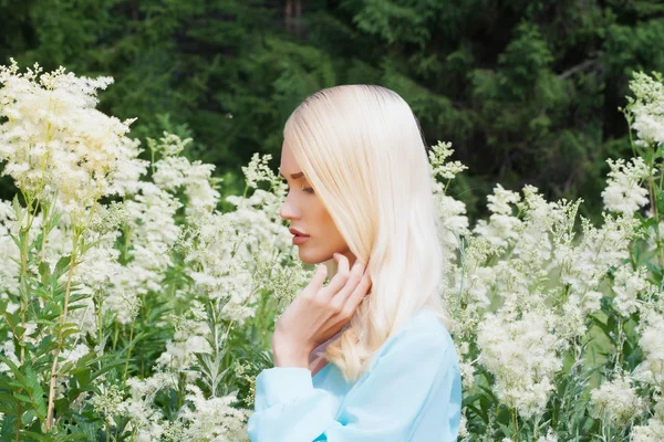 Krásná mladá blondýnka s květy — Stock fotografie