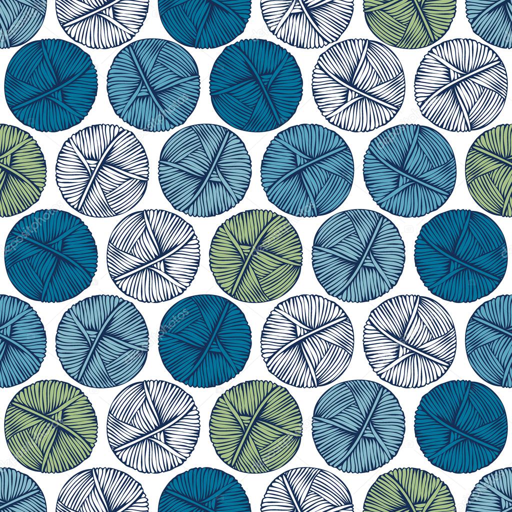 Blue and green balls of yarn on a light background.