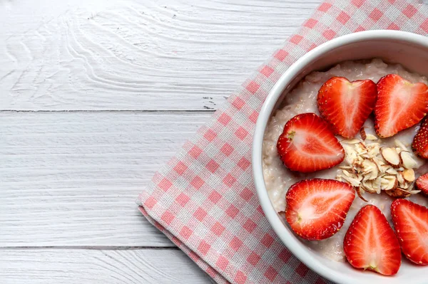 燕麦粥配草莓 杏仁配白碗 健康早餐与燕麦片和新鲜的有机草莓 健康食品概念 — 图库照片