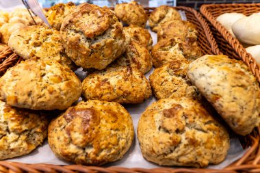 Sıcak, ev yapımı bisküvilerle dolu sepetler yoğun bir fırında sergileniyor. Müşteriler en sevdikleri yemeği seçerken fırında pişirilen malların kokusundan hoşlanırlar..