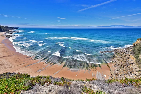 Magoito Sahili manzarası bir yaz günü. Plajda hafif bir dalgalanma var ve su ve gökyüzü mavi ve belirgin bir ufuk çizgisi var. Perspektif bir hava görüntüsünü temsil ediyor. Portekiz 'in Sintra Lizbon ilçesine bağlı bir beldedir..