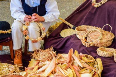 Galiçya 'daki bir sanat fuarında mısır kabuklarından taç ve saç bandı yapan sanatçı kadın.
