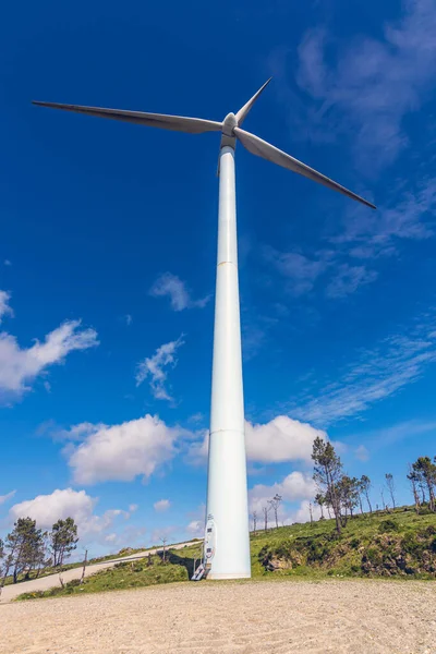 Galiçya 'da bir rüzgar tarlasından peyzaj, ön planda bir rüzgar türbini