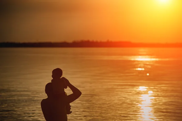 Père et fille admirant le coucher du soleil sur le lac — Photo