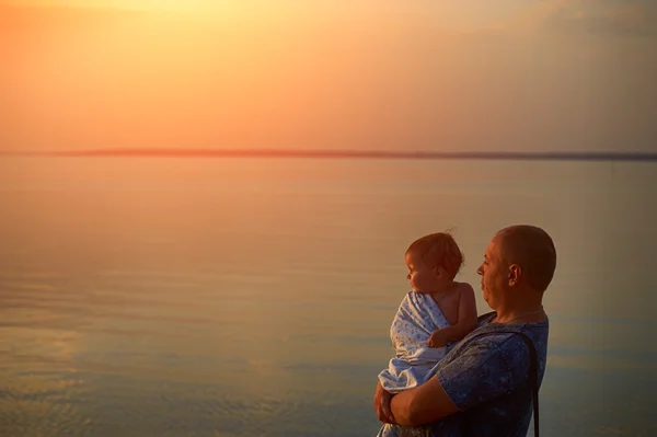 Padre e hija admirando la puesta de sol en el lago — Foto de Stock