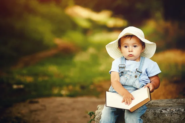 小女孩在日落公园里拿着本书 — 图库照片