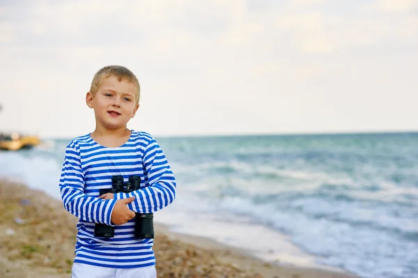El niño en el chaleco con los prismáticos, camina por la playa —  Fotos de Stock