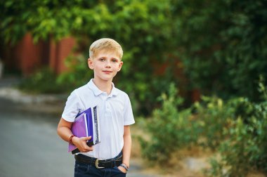 Kitaplar ile ilkokul öğrencisi. Çocuğun okul sırt çantası.