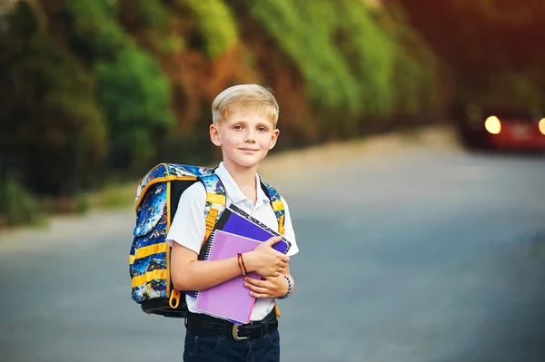 Elementary school student med böcker. Bakom pojkens skola ryggsäck. — Stockfoto