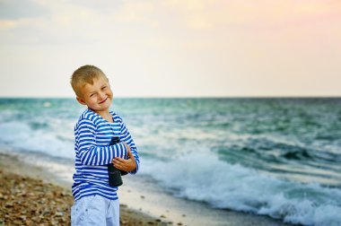 Küçük çocuk yeleği dürbünlü, kumsalda yürür
