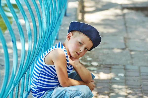 Retrato de un hermoso niño en un parque de la ciudad. Vestido en un estilo náutico  . —  Fotos de Stock