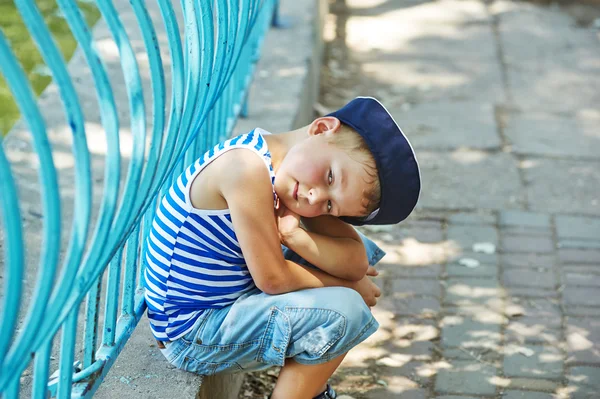 Retrato de un hermoso niño en un parque de la ciudad. Vestido en un estilo náutico  . —  Fotos de Stock