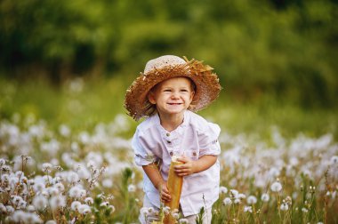 Dandelions ve Fransız ekmeği elinde alanı küçük çocuk