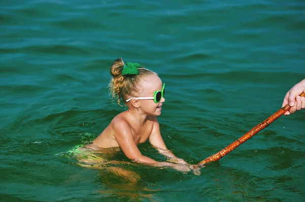 girl playing in the sea , learning to swim