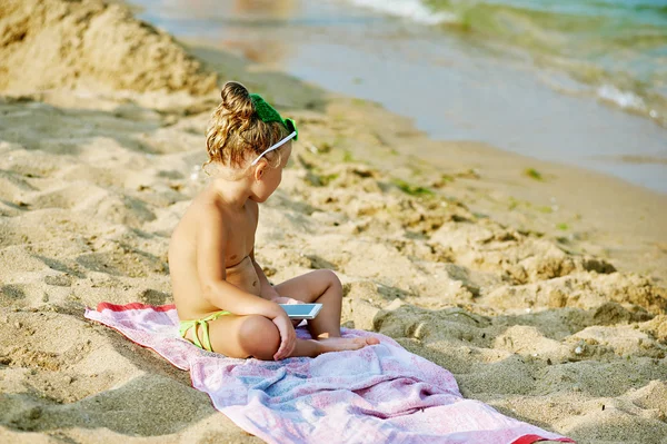 Małe słodkie dziewczyny gry z telefonu na plaży — Zdjęcie stockowe