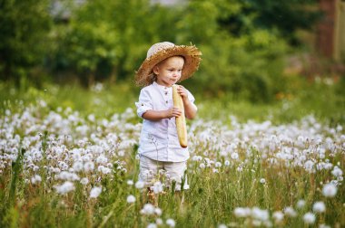 Dandelions ve Fransız ekmeği elinde alanı küçük çocuk