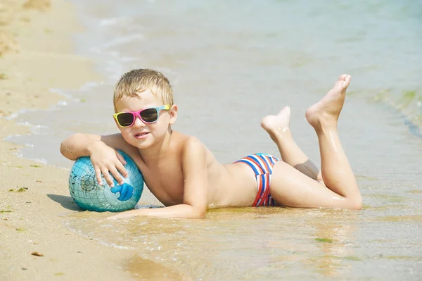 男孩与球描绘了世界各地的海滩上 — 图库照片