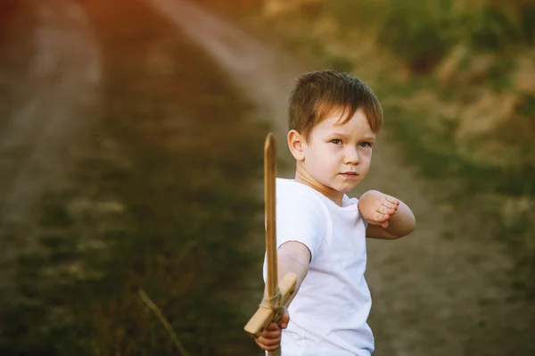 Un niño juega con una espada de madera —  Fotos de Stock