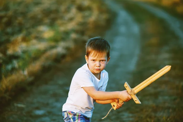 Ένα αγόρι παίζει με ένα ξύλινο σπαθί — Φωτογραφία Αρχείου