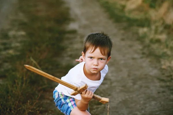 Un niño juega con una espada de madera —  Fotos de Stock