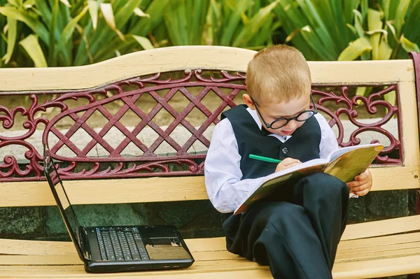 ノート パソコンに座っている美しい少年がメガネ — ストック写真