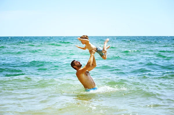 Padre e figlio felici che giocano in mare. Festa del papà — Foto Stock