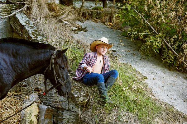 Pojke som poserar med en häst efter träningen. Ranch — Stockfoto