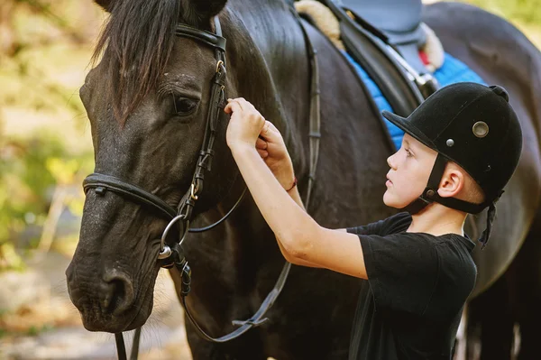 Le garçon selle un cheval et resserre la circonférence. Le premier plan . — Photo