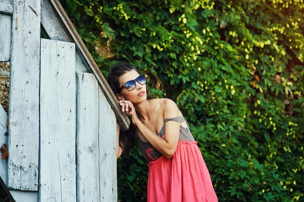 Young beautiful girl sitting on wooden stairs in the evening — Stock Photo, Image