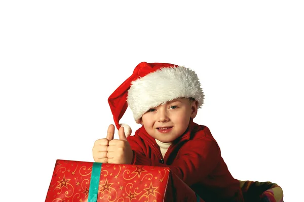 Handsome young boy in Santa's red hat holding a gift box — Stock Photo, Image