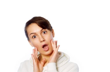 Şaşırmış ve ağzı açık bir şekilde kafasını tutan güzel bir kızın yakın plan portresi. Beyaz arkaplan.