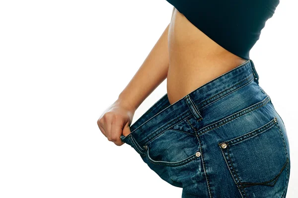 Belle jeune femme avec de gros jeans, isolée sur blanc — Photo