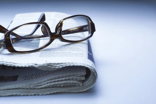 Glasses on newspaper, blue tone — Stock Photo, Image