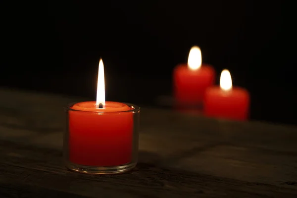 La esperanza ilumina Tres velas en la vieja mesa de madera —  Fotos de Stock