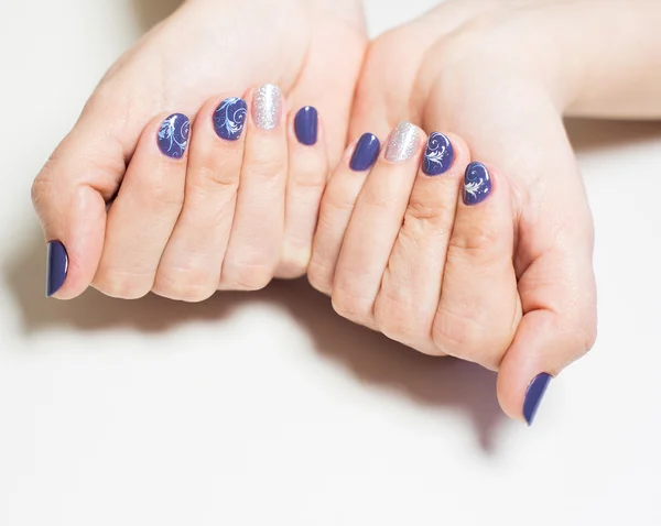 Manos femeninas con manicura profesional azul y plata — Foto de Stock